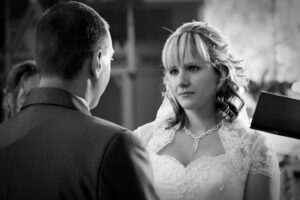 A menyasszony a templomi esküvőn érzelmesen néz a párja szemébe