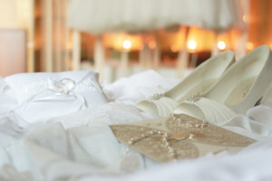 A menyasszony cipője, ékszerei és kiegészítői az ágyon