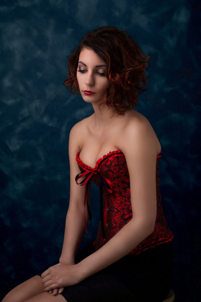 Glamour fotó egy lányról, piros mintás fűzőben.